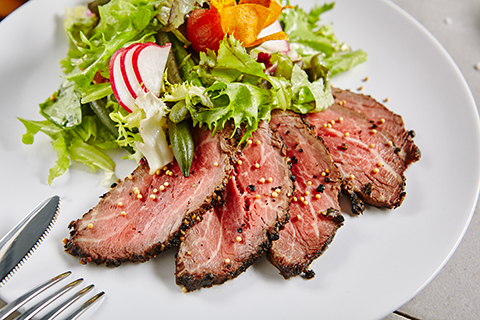 Steak salad. Thin cut, rare steak with peppercorns & fresh greens, radishes & toasted beet chips